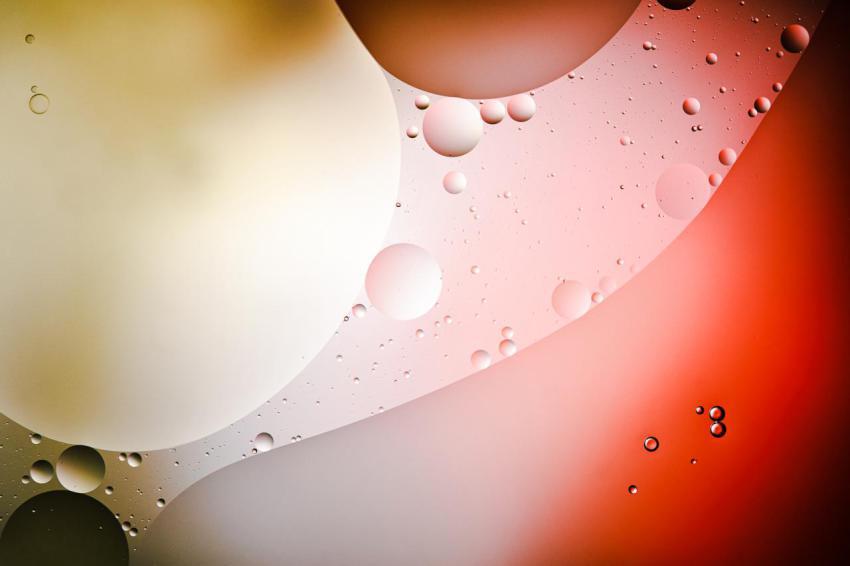 Abstract background from mixed water and oil bubbles in red and